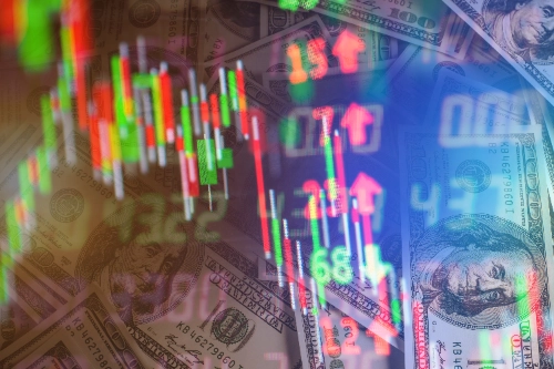 Um close-up de uma sobreposição digital mostrando um gráfico de velas de ações (em tons de verde e vermelho) sobre um fundo preenchido com notas de cem dólares.