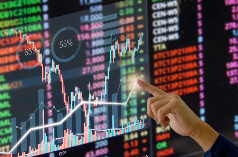 Una mano interactúa con una pantalla virtual con gráficos bursátiles, velas y datos de Forex.